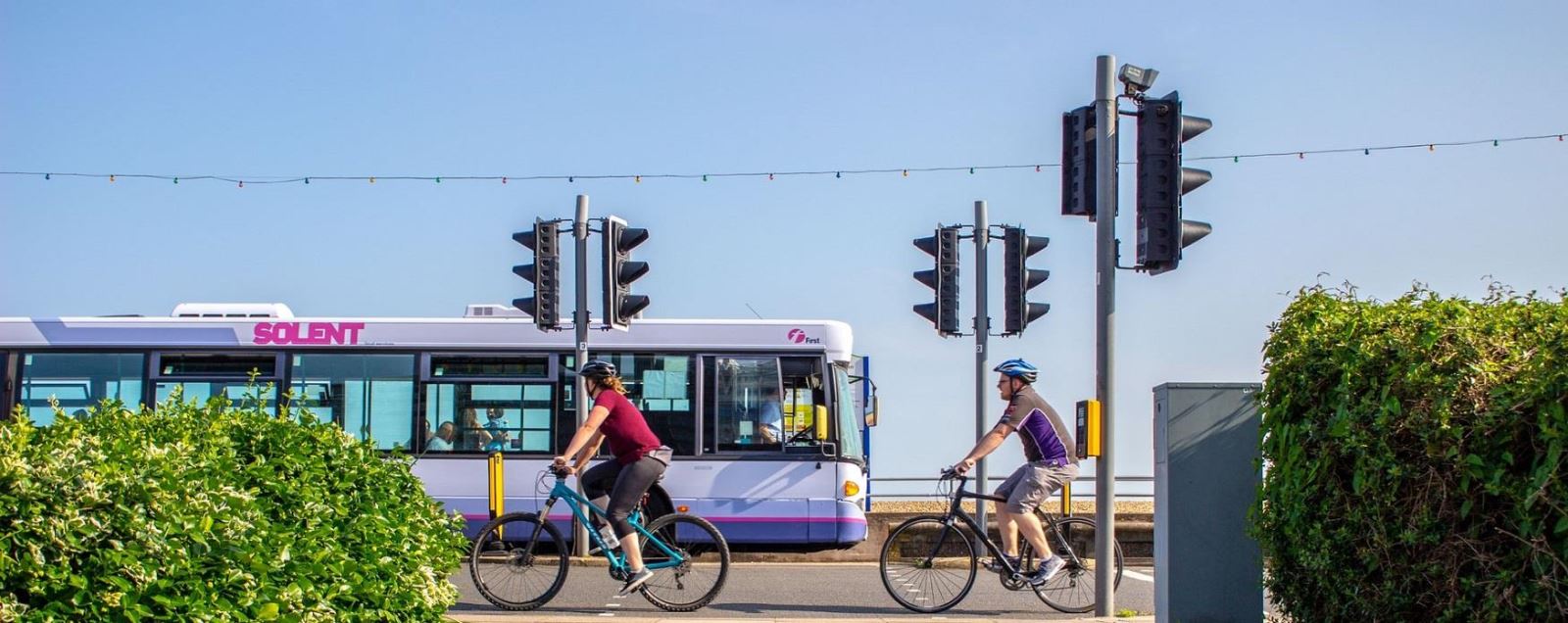 First bus driving along Southsea Seafront, with cyclists in the foreground