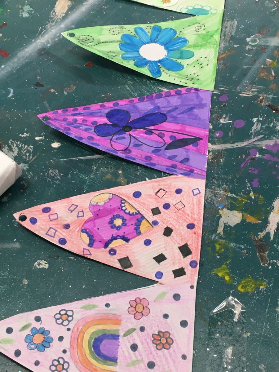 Colourful bunting adorned with rainbows hearts and flowers