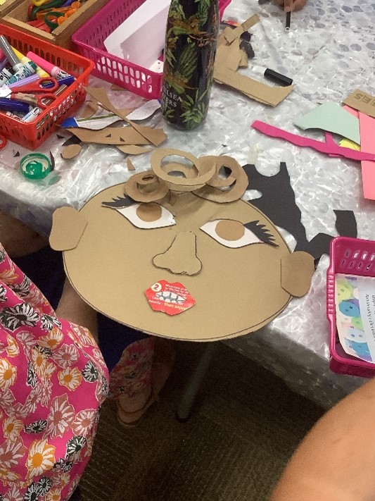 Cardboard head of a lady with curly hear and red lipstick